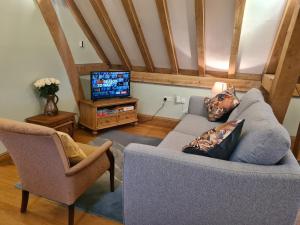 a living room with a couch and a tv at Renovated Loft on Working Farm in Mayfield