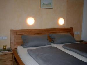 two beds in a bedroom with two lights on the wall at Landeckhof in Oberwolfach