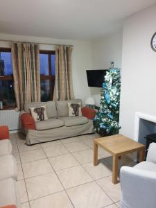 a living room with a christmas tree and a couch at Ulster Cottages in Bushmills
