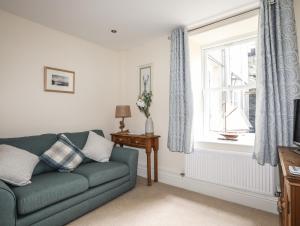 a living room with a green couch and a window at Hyfrydle in Porthmadog