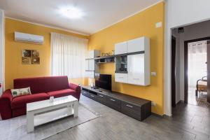 a living room with a red couch and a tv at La casa di Marta in Noto