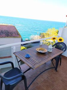 einen Holztisch und Stühle auf einem Balkon mit Meerblick in der Unterkunft Ca la Nuri Pis 2 con Vistas al Mar in Llança