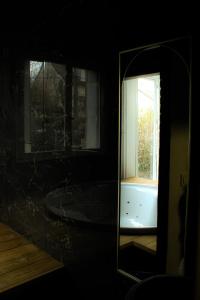 ル・ブラン・メニルにあるSeasides Paris - Suite Monroeの鏡付きのバスタブ、窓