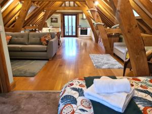 a living room with a couch and a living room with wooden ceilings at Renovated Loft on Working Farm in Mayfield