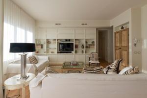 ein Wohnzimmer mit einem weißen Sofa und einem Fernseher in der Unterkunft Casa Gramsci luxury apartment in Pesaro