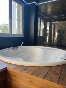a large white tub in a bathroom with blue walls at Le Seaside - Love Room Jacuzzi et Day Use - Parc des Expos Bourget, CDG 15 min in Le Blanc-Mesnil +22 photos