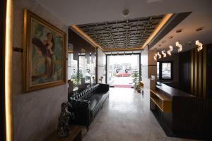 REF İNN HOTEL في أوردو: غرفة انتظار مع كراسي جلدية سوداء ولوحة
