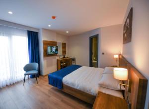 ein Hotelzimmer mit einem Bett und einem Stuhl in der Unterkunft REF İNN HOTEL in Altınordu + 17 Fotos