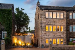 una casa di mattoni con luci di Natale sopra di Lower Arthur's Cottage in Saddleworth, Manchester a Oldham