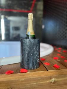 - une bouteille de champagne dans un porte-drapeau noir sur une table dans l'établissement Seasides Paris - Suite Monroe, au Blanc-Mesnil