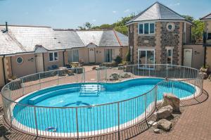 a large swimming pool in front of a house at Waterwitch Cottage in Newquay +16 photos