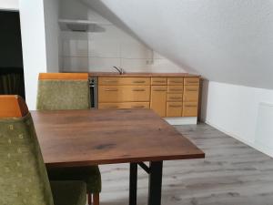 - une cuisine avec une table en bois et des chaises dans l'établissement Stilvoll Wohnen in Oldenburg Kreyenbrück Apartments, à Oldenbourg