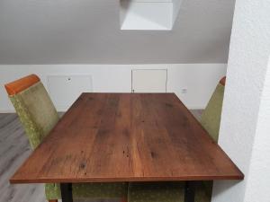 a wooden table with two chairs in a room at Stilvoll Wohnen in Oldenburg Kreyenbrück Apartments in Oldenburg
