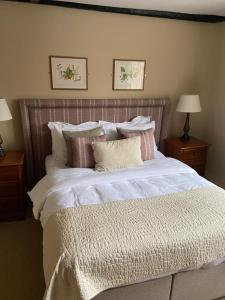 a bedroom with a large bed with white sheets and pillows at The Red Lion Eaton in Norwich +14 photos