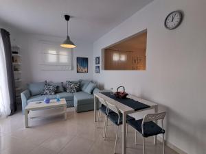 a living room with a couch and a table and a clock at Almyra seaside in Perdhika