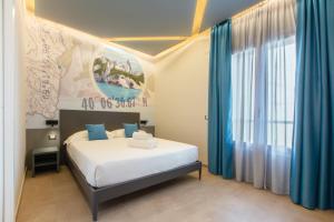 1 dormitorio con 1 cama con cortinas azules en ARKADIA Rooms & Apartments, en Cagliari
