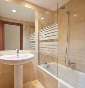 a bathroom with a sink and a glass shower at Iraipe Logroño Hotel in Logroño