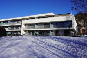 een wit gebouw met sneeuw ervoor bij Gartenappartement Leonsberg in Bad Ischl