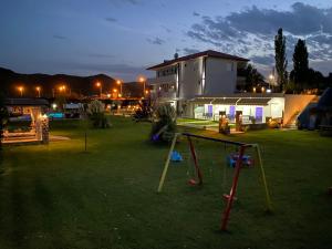 a yard with a table in the grass at night at A Ponte Studios & Apartments in Sykia Chalkidikis