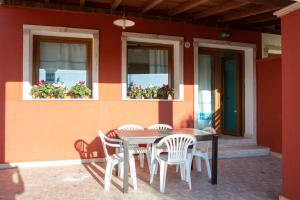 una mesa y sillas en un patio con ventanas en Bellavista, en SantʼAndrea