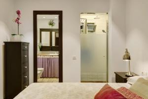 a bedroom with a bed and a bathroom with a mirror at Vcv Apartamento San Telmo in Las Palmas de Gran Canaria