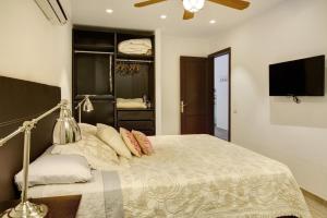 Vcv Apartamento San Telmo في لاس بالماس دي غران كاناريا: غرفة نوم بسرير كبير وتلفزيون