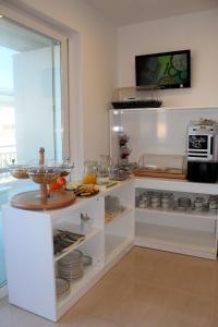 kuchnia z białymi szafkami z jedzeniem na wystawie w obiekcie Atlantis Lodge w mieście Marsalforn