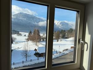 a window with a view of snow covered mountains at Gloria Holiday - Apartment Bohinj in Bohinj