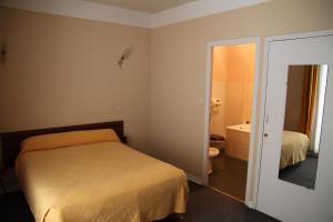 コルテにあるHôtel Sampiero Corsoのベッドルーム1室(ベッド1台付)、バスルーム(バスタブ付)が備わります。