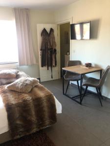 een slaapkamer met een bed en een tafel met stoelen bij Logies Dampoort in Gent