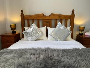 Una cama con almohadas y una manta gris. en Blackwood House, en Healesville