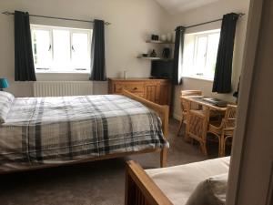 a bedroom with two beds and a table and chairs at The Studio in Wiveliscombe