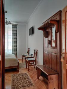 a living room with a wooden door and a table at La Teo Pensiune si Pivnita in Sighişoara