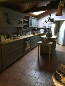 a large kitchen with white cabinets and a table at Maison à 10 min du puy du fou et parc de Maulévrier in Saint-Amand-sur-Sèvre