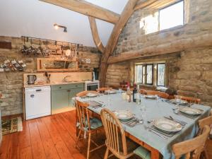 una cucina e una sala da pranzo con tavolo e sedie di Wyndell Cruck Cottage a Sheffield