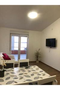 a living room with a table and a tv at Beach front Paradise Apartment in Sukošan
