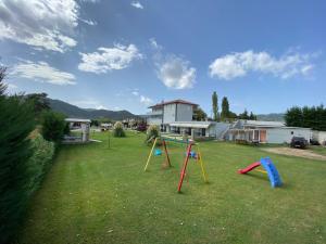a yard with two playground equipment in the grass at A Ponte Studios & Apartments in Sykia Chalkidikis