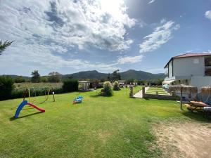 a yard with a swing set in the grass at A Ponte Studios & Apartments in Sykia Chalkidikis