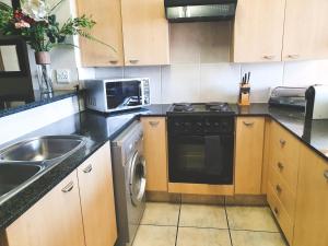 a kitchen with a sink stove and a microwave at Westpoint Sandton Apartments in Johannesburg