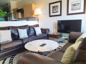 a living room with leather couches and a coffee table at Westpoint Sandton Apartments in Johannesburg