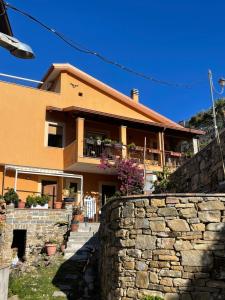 a house with a stone wall in front of it at Casa Vacanze Rì Zìì in Montecorice