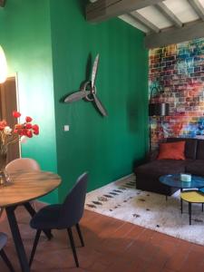 una sala de estar con una pared verde y un ventilador de techo. en Le Mondrian atypique Intra-Muros, en Aviñón