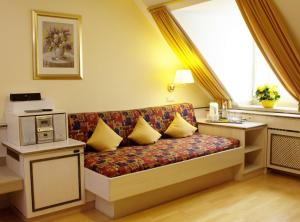 a couch with pillows in a room with a window at AppartementPension Zum Zacherl in Feldkirchen