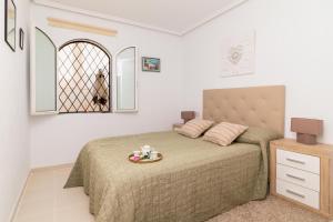 a bedroom with a bed with a plate on it at Espanatour AZAHAR DEL MAR in Torrevieja +22 photos