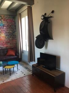 sala de estar con sofá y TV en Le Mondrian atypique Intra-Muros, en Aviñón