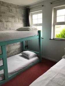 a room with two bunk beds and two windows at Finn McCools Giants Causeway Hostel in Bushmills