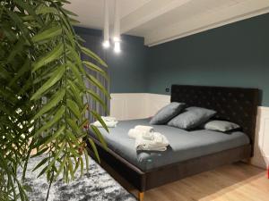 ein Schlafzimmer mit einem Bett mit blauen Wänden und einer Pflanze in der Unterkunft B&B Il Duomo in Gioia Tauro
