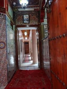a hallway in a building with a red rug at Hotel imouzzer in Marrakech