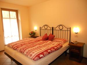 a bedroom with a large bed with red pillows at Residence Villa Avisio in Canazei