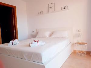 a white bed with two towels on top of it at Spacious luxe apartment on Mar Menor Golf Resort with Padel, Fitness, Wellness facilities in Torre-Pacheco +25 photos